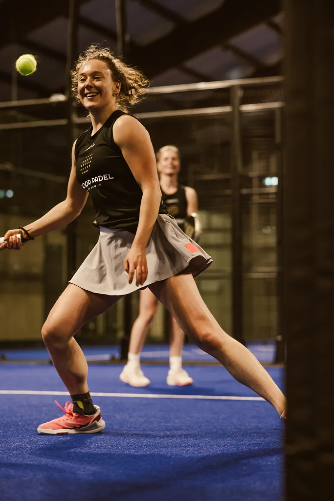 Speelster slaat lachend een forehand